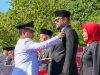 Pj Gubernur Sultra, Andap Budhi Revianto saat menyerahkan surat keputusan Presiden Republik Indonesia tentang Penganugerahan tanda kehormatan Satyalancana Karya Satya kepada 12 ASN Pemprov Sultra pada peringatan HUT ke-60 Provinsi Sultra bertempat di Halaman Kantor Gubernur Sultra.