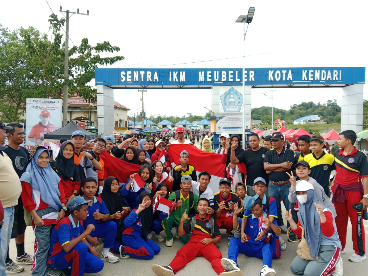 Dikbud Sultra bersama siswa dan guru saat membagikan bendera merah putih ke masyarakat bertempat di Kolam Retensi Kendari.