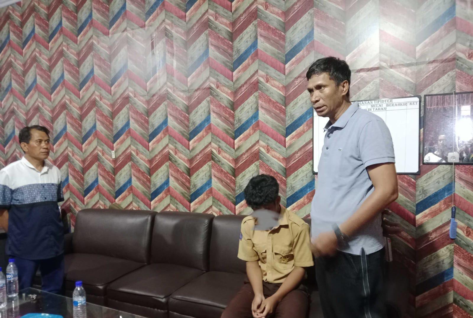 Kepala Dikbud Sultra, Yusmin (kanan) bersama pelaku berisial F (kiri) yang menyamar sebagai pelajar saat diamankan di Mapolresta Kendari.