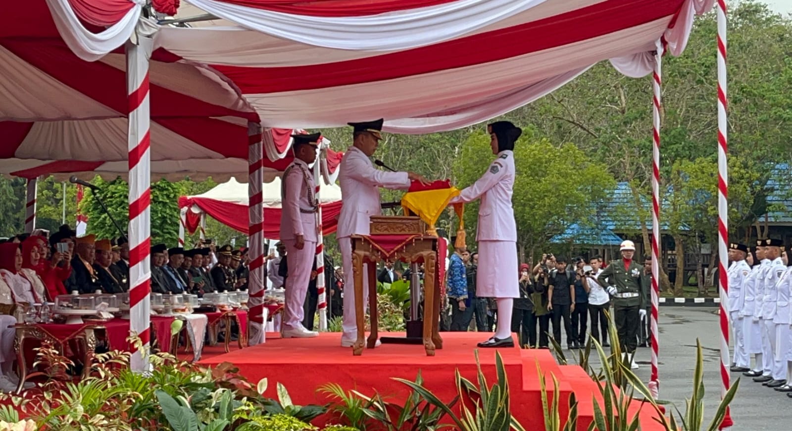 Pembawa baki, Wa Ode Ariqa Hidayastri, siswa asal Kota Kendari naik ke podium untuk menerima bendera dari Gubernur Sultra Andi Sumangerukka. (FOTO: FAYSAL/MS)