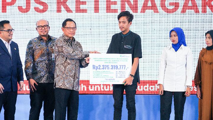 Menteri Dalam Negeri, Tito Karnavian saat menyerahkan manfaat Jaminan Sosial Ketenagakerjaan secara simbolis kepada lima ahli waris peserta. (Dok. Istimewa) 