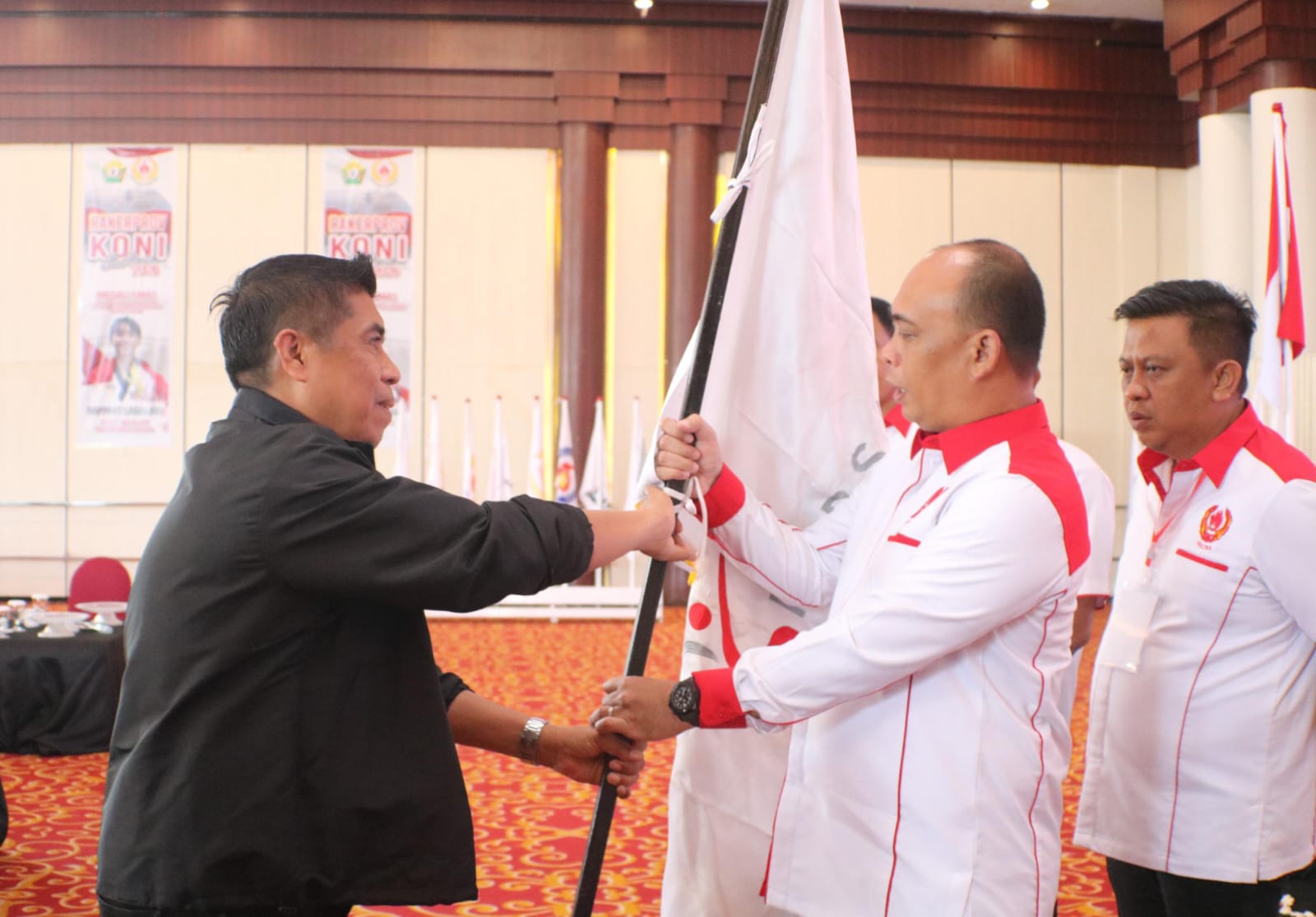Wakil Ketua OKK FGI Sultra, Andi Sultan Bakri, SKM, M.Sc, saat menyerahkan bendera pataka FGI kepada Ketua Umum KONI Sultra, Andi Ady Aksar. (Dok. Istimewa)